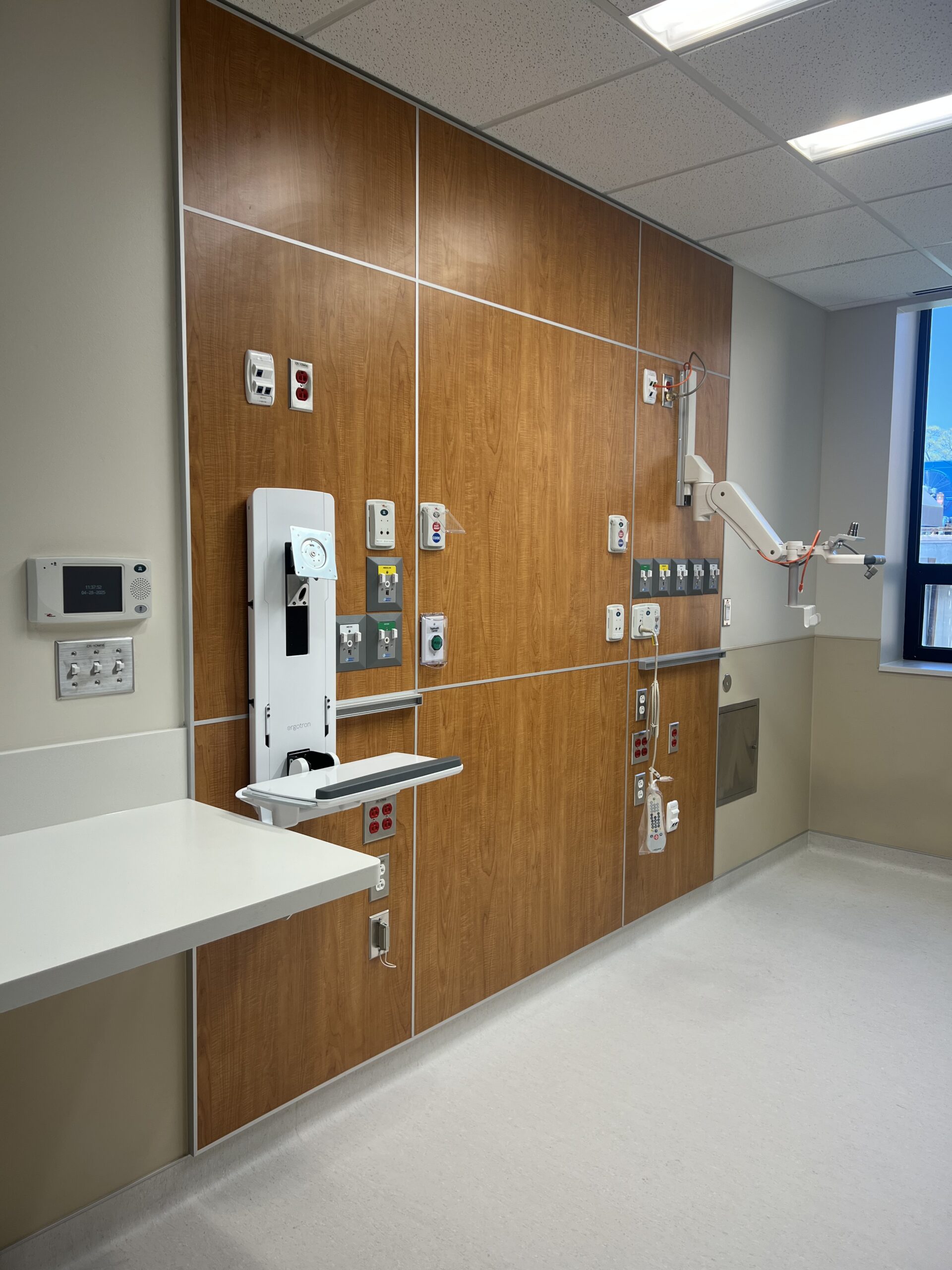 ICU patient room headwall with medical gas outlets and equipment connections, wood-paneled wall, at Memorial Hospital Belleville